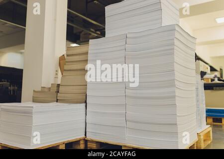 piles de feuilles imprimées de carton sur des palettes en bois closeup. industrie de l'impression. Banque D'Images