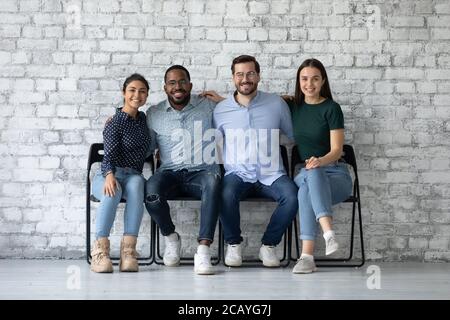 Portrait souriant divers candidat à un poste assis sur des chaises dans le hall Banque D'Images