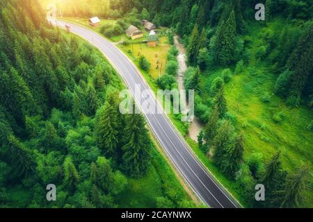 Vue aérienne de la route dans la belle forêt verte au coucher du soleil Banque D'Images