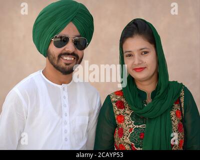 Un jeune couple Sikh indien à la mode porte des tenues assorties en vert et pose pour l'appareil photo. Banque D'Images