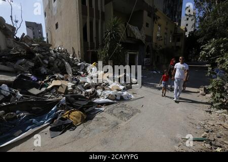 Beyrouth, Beyrouth, Liban. 9 août 2020. Les Libanais marchent à côté des décombres près du site de l'explosion dans le port de Beyrouth, après une explosion colossale qui s'est produite quelques jours auparavant en raison d'une énorme pile de nitrate d'ammonium qui languit depuis des années dans un entrepôt portuaire. L'énorme explosion chimique qui a frappé le port de Beyrouth, dévastant de grandes parties de la capitale libanaise et faisant plus de 150 morts, a laissé un cratère de 43 mètres (141 pieds) de profondeur, a déclaré un responsable de la sécurité. L'explosion du mardi, qui a été ressentie à travers le pays et jusqu'à l'île de Chypre, a été enregistrée par les capteurs de l'Amérique Banque D'Images
