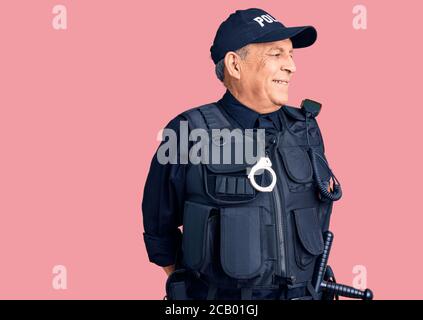 Homme de haut niveau portant un uniforme de police, regardant de côté avec le sourire sur le visage, expression naturelle. Riant confiant. Banque D'Images