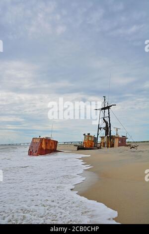 Le chalutier de pêche Ocean Pursuit coincé sur la plage au large de Oregon Inlet à Nags Head, NC le 1er mars 2020 et 5 mois plus tard, s'enfonce dans la plage. Banque D'Images