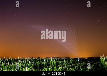 Hartheim am Rhein, Allemagne. 09e août 2020. Un système de gicleurs irrigue un champ après le coucher du soleil. En raison des températures élevées et de la sécheresse persistante, l'Allemagne connaît actuellement une période de sécheresse historique. (La photo a été prise avec un long temps d'exposition) Credit: Philipp von Ditfurth/dpa/Alamy Live News Banque D'Images