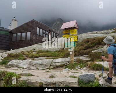 Slovaquie, haute montagne de Tatra, 13 septembre 2018: Jeunes hommes randonneurs regardant le panneau de sentier en face de teryho chata chalet de montagne à la belle Banque D'Images