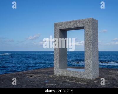 Espagne, îles Canaries, Garachico, décembre 19, monument en marbre statue carrée forme de cadre sur la rive avec ciel bleu et fond de mer Banque D'Images