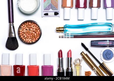 Produits cosmétiques et de maquillage isolés sur une couche plate blanche. Vernis à ongles boules de fard à joues avec des brosses parfums rouge à lèvres et autres accessoires Banque D'Images