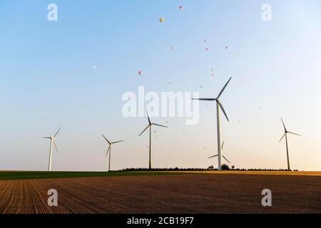 Éoliennes entre les champs, au-dessus d'eux ballons à air chaud, lumière du soir, Warstein, pays aigre, Rhénanie-du-Nord-Westphalie, Allemagne Banque D'Images