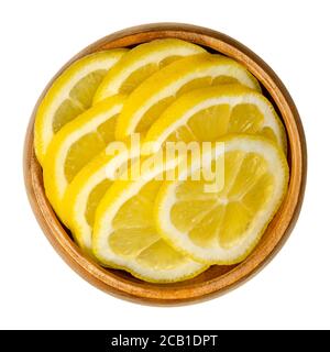 Tranches de citron frais dans un bol en bois. ​​ripe en tranches d'agrumes jaunes. Citron limon. Les citrons sont utilisés à des fins culinaires et pour le nettoyage. Banque D'Images
