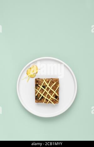 Flapjack au gingembre recouvert de gingembre râpé sur une assiette blanche Banque D'Images