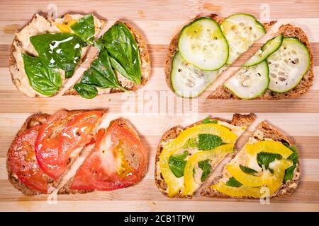 Snadwiches à base de plantes sur une planche à découper, vue de dessus. Déjeuner végétalien, en-cas végétariens, repas santé Banque D'Images