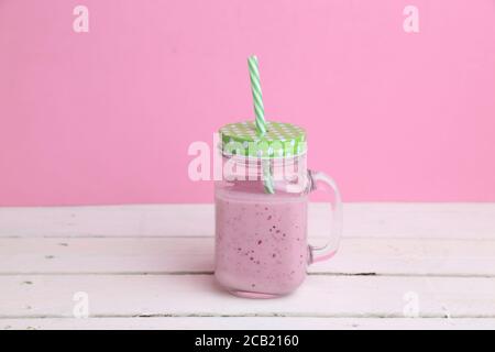 Pot de smoothie aux baies sur fond rose Banque D'Images