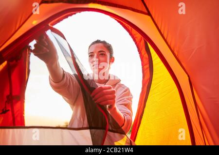 Belle jeune femme dans la tente de camp de dézipping à capuche Banque D'Images