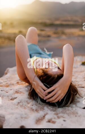 Femme à la plage portant un maillot de bain jaune Banque D'Images