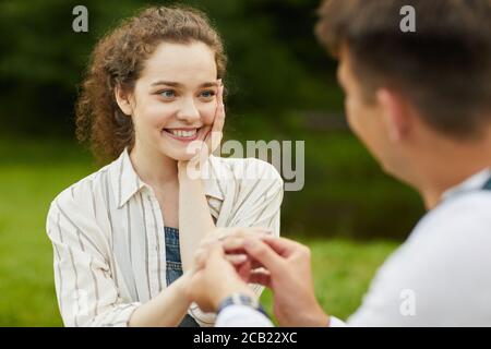 Gros plan d'une belle jeune femme qui regarde le petit ami tout en mettant l'anneau de fiançailles sur le doigt pendant les vacances romantiques Banque D'Images