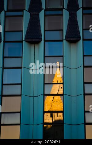 Vue détaillée du reflet voilé du bastion des pêcheurs, alias Halaszbatya, tours de conte de fées dans les fenêtres de l'hôtel moderne. Banque D'Images