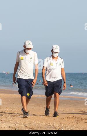 Punta Umbria, Huelva, Espagne - 7 août 2020: La garde de plage de Junta de Andalucia contrôle la distance sociale et l'utilisation du masque de protection Banque D'Images