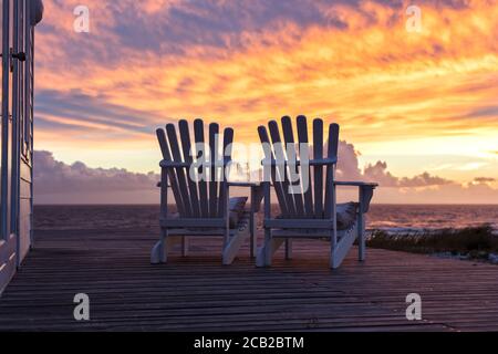 Deux chaises vides donnant sur la magnifique vue sur le coucher du soleil à la plage Banque D'Images