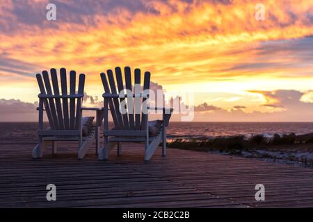 Deux chaises vides donnant sur la magnifique vue sur le coucher du soleil à la plage Banque D'Images
