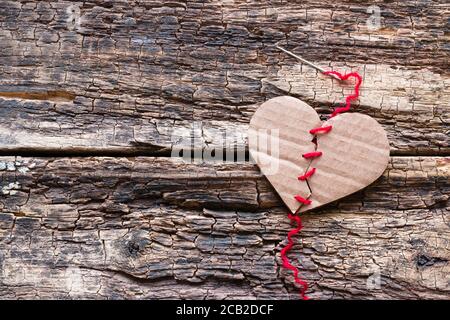 un coeur brisé est cousu avec un fil rouge Banque D'Images