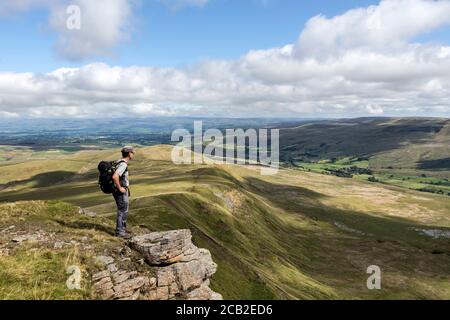 Walker appréciant la vue de Wild Boar tomba au-dessus de Mallerstang, Cumbria, Royaume-Uni Banque D'Images