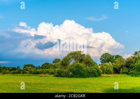 Avant la tempête d'été. Des nuages spectaculaires s'affichent dans un paysage verdoyant et ensoleillé. Banque D'Images