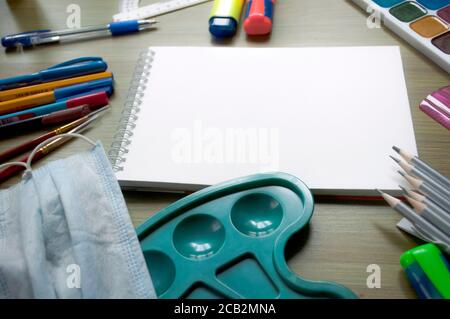 Maquette d'éducation avec papeterie pour élèves et feuille vierge de papier à croquis blanc sur fond en bois. Jeu de mises en plan. Concept d'éducation Banque D'Images