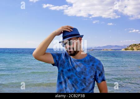 jeune homme en chapeau bleu sur la plage
