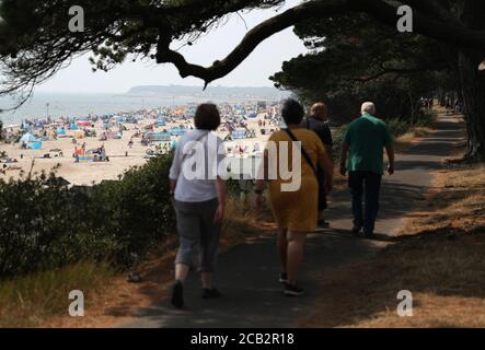 Les gens apprécient le temps chaud sur la plage d'Avon à Mudeford, Dorset. Banque D'Images