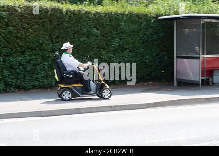 Slough, Berkshire, Royaume-Uni. 10 août 2020. Un homme conduit son scooter de mobilité le long de la chaussée. Selon les rapports du Telegrap au cours du week-end, il y a encore la possibilité que les personnes obèses et les plus de 50 ans aient à se verrouiller en cas de deuxième vague du coronavirus. Crédit : Maureen McLean/Alay Live News Banque D'Images