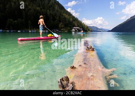 Young boy sur paddleboard sur le lac Banque D'Images