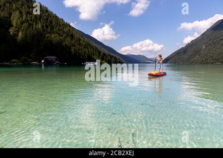 Young boy sur paddleboard sur le lac Banque D'Images