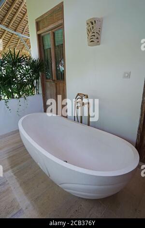 Baignoire extérieure blanche élégante décorée dans un patio et une terrasse naturels Banque D'Images