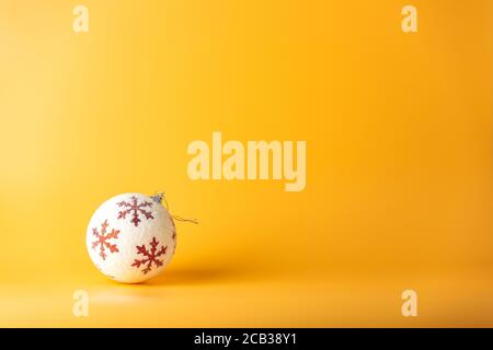 Boule de Noël. Fond de Noël avec ornements blancs et rouges sur jaune. Carte de vœux de joyeux noël. Hiver vacances thème Noël. Bonne Année. Banque D'Images