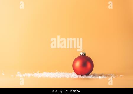 Boule de Noël. Fond de Noël avec boule rouge sur jaune. Carte de vœux de joyeux noël. Hiver vacances thème Noël. Bonne Année. Espace pour le texte Banque D'Images