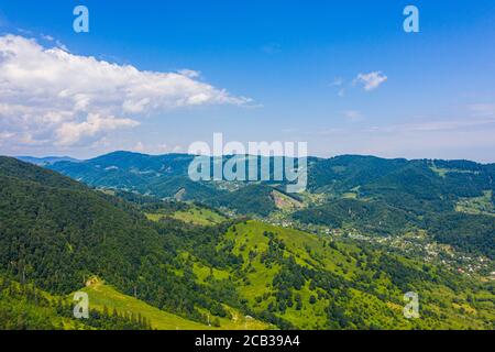 Vue aérienne sur la montagne verte, la forêt de pins, la rivière et le village. Carpathian, Ukraine. Banque D'Images