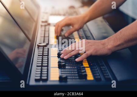 Équipe d'ingénieurs légers travaillant à la préparation de la scène de concert musical. Banque D'Images