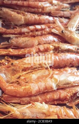 Un plateau de grosses crevettes géantes en noir et blanc et monochrome. Ils sont préparés dans du beurre à l'ail pour griller et dévorer. Crevettes déveinées, un BLOB de beurre à l'ail, et fraîchement préparé. Banque D'Images