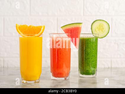 Un verre de jus d'orange, de melon d'eau et de smoothie aux épinards. Banque D'Images