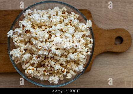 Pop-corn dans un bol en verre. Maïs transformé. En-cas au film. Au cinéma. Avant le film. Banque D'Images