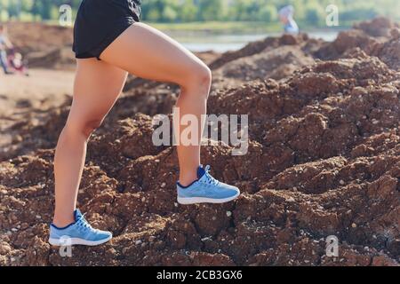 Woman runner jambes s'exécutant sur sentier de montagne. Pieds de femme runner exécutant plus de pierres sur le sentier de montagne. Banque D'Images