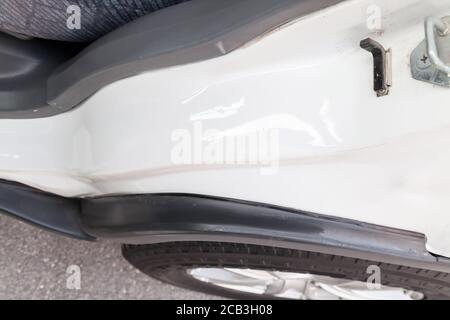 Gros plan d'une arche en métal blanc d'une roue de carrosserie d'un vus japonais dans un parking, vue de dessus de l'aile après le redressement et la peinture après un accident. Banque D'Images