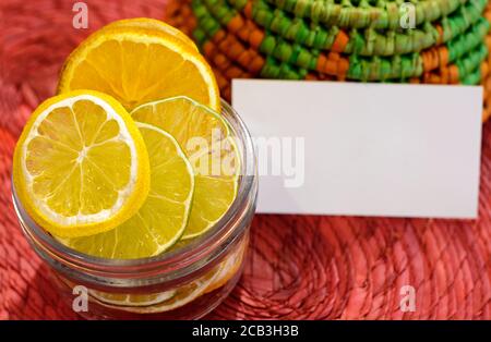 Fruits secs citron, lime et orange dans un verre et petite carte blanche pour Banque D'Images