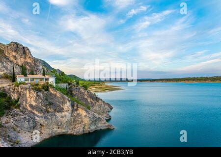 Un grand réservoir d'eau, barrage avec une maison sur une montagne en arrière-plan Banque D'Images