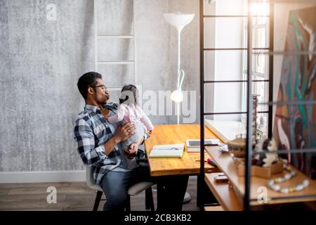 jeune beau père embrassant bébé gurl tout en étant assis dans la chambre. gros plan phoot. espace de copie Banque D'Images