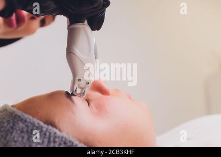 Procédé de l'appareil GPL de massage de drainage lymphatique. L'esthéticienne thérapeute fait un massage du visage rajeunissant pour le modèle dans un salon de beauté. Gros plan Banque D'Images