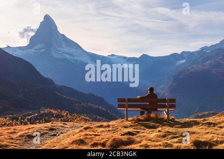Vue pittoresque sur le sommet du mont Cervin et siège touristique sur un banc en bois dans les Alpes suisses. Hôtel Zermatt, Suisse. Photographie de paysage Banque D'Images
