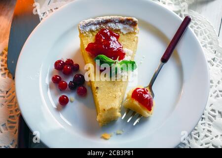 Gâteau de citrouille sucré Halloween avec crème de canneberges et fourchette sur une assiette. Cuisine traditionnelle de vacances Banque D'Images