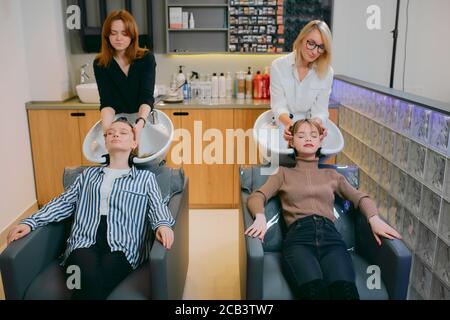 jeune et belle femme obtenant des procédures de beauté dans le saloon de coiffure, profiter et se détendre tout en étant allongé sur un lit spécial pour laver et teindre les cheveux dans le saloo Banque D'Images