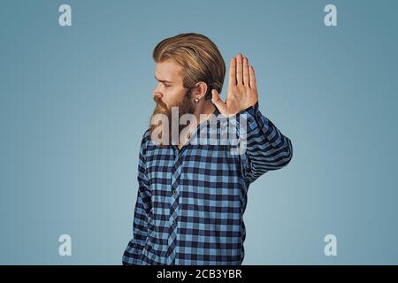 Homme d'affaires sérieux ne montrant pas, arrêtez-vous là geste. Petit garçon avec barbe en chemise à carreaux bleu isolée sur fond bleu studio. Negati Banque D'Images